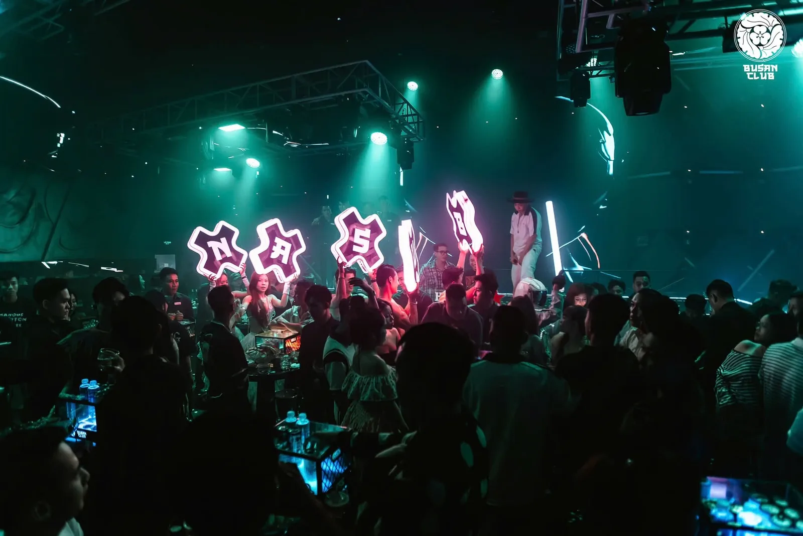Busan Club Cần Thơ — chữ neon và ánh đèn xanh ngọc trên sàn